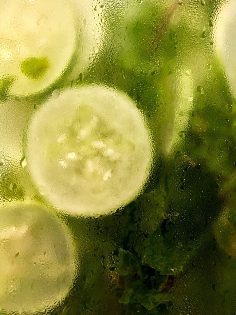 sliced pickled cucumbers in a glass jar covered with condensation