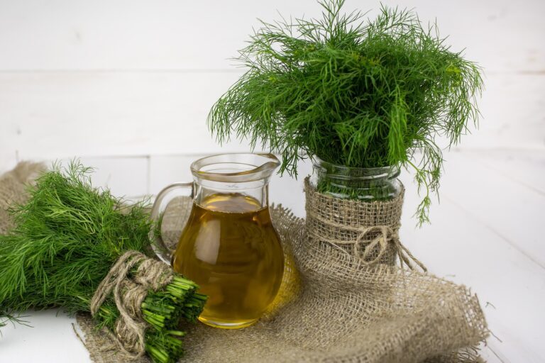 Dill in water next to olive oil on chopping board