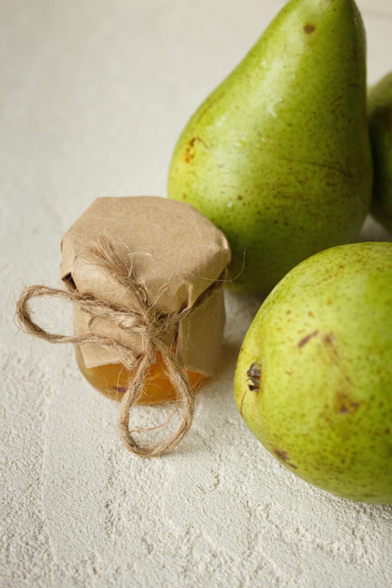 Close up photo of conference pears with a small jar of pear jam