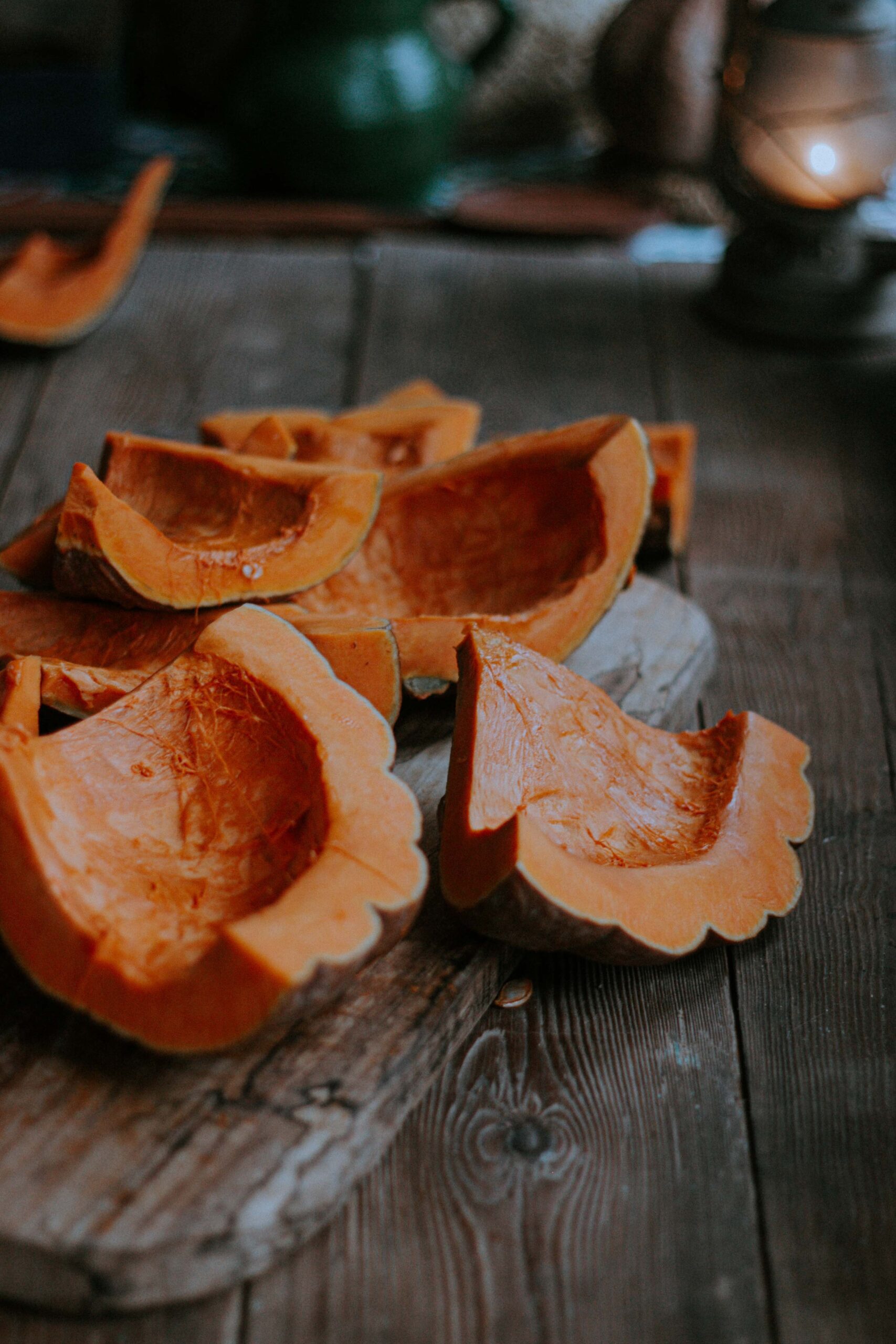 Wedges of deseeded pumpkin on chopping board on wooden work surface