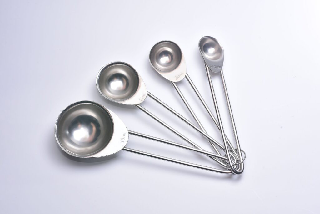 Set of chrome measuring spoons on a ring; fanned out on a white background