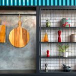 Kitchen tools on display against a grey wall.