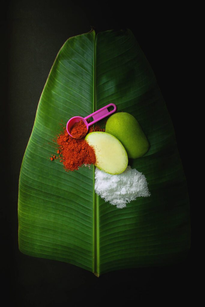 Small pink measuring spoon with spices on a banana leaf