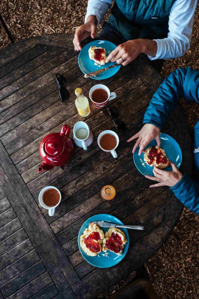 Rhubabr compote being enjoyed with scones and tea and a picnic table.