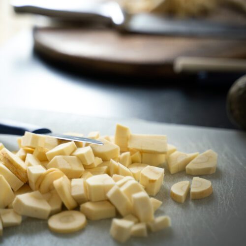 Pieces of chopped parsnips on a board.