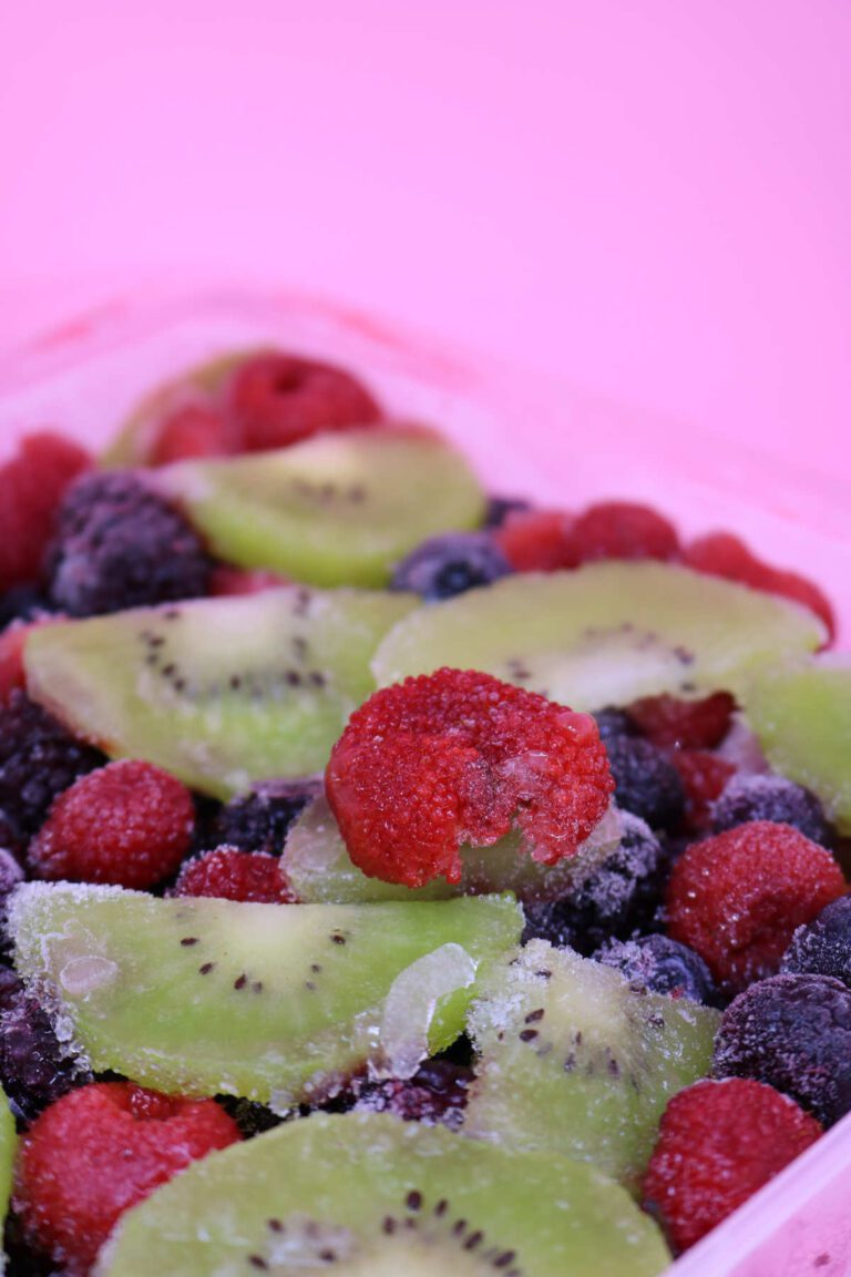 A box of frozen fruits including varied berries and kiwi slices.