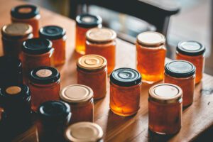 Glass jars and lids filled with delicious orange jam preserves